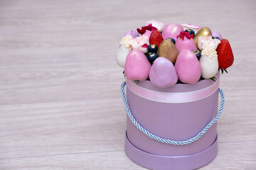 delicious bouquet of strawberries in white, pink and gold chocolate on a light background.