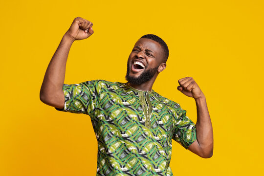 Black man showing positive emotions over yellow background
