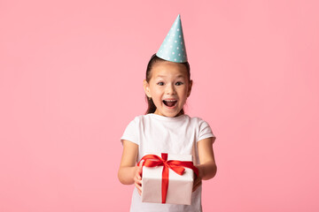 Happy asian girl holding gift box at studio