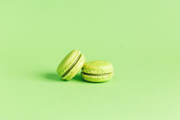 Tasty french macaroons on a light green pastel background.