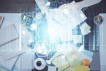 Social network theme hologram over hands taking notes background. Concept of global international people connect. Double exposure