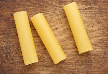 raw cannelloni pasta on a brown wooden background
