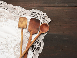 empty wooden spoon and spatula on a brown wooden background from boards