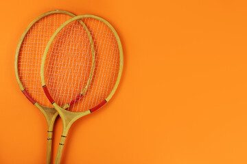 badminton rackets on a bright orange background. Copy space for your text