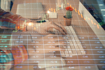 Double exposure of stock market chart with man working on computer on background. Concept of financial analysis.