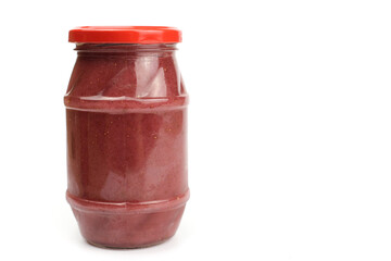 Glass jar with strawberry or raspberry jam isolated on the white background