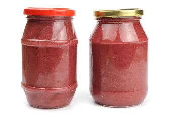 Glass jars with strawberry or raspberry jam isolated on the white background