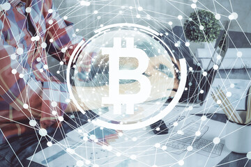 Crypto currency theme hologram with businessman working on computer on background. Concept of blockchain. Multi exposure.