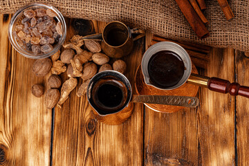 Shiny copper turk with brewed coffee on brown wooden table