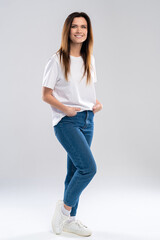 Full portrait of a beautiful young happy woman standing over white background.