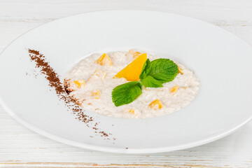 Oatmeal with mango in a white, round plate
