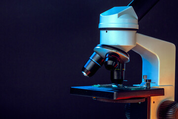 Microscope with lenses close up against dark background