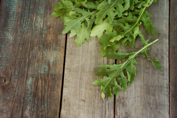 The rucola lies on old wooden boards. With copy space. Top view