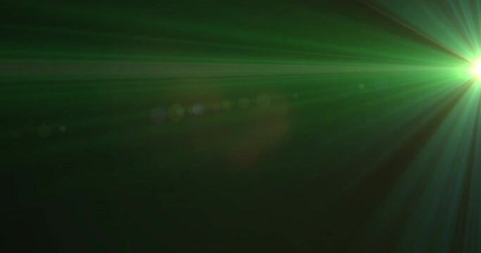 Glowing green rays of light moving against black background