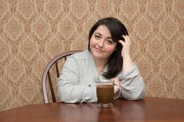 Plus size woman with a cup of coffee in a bathrobe
