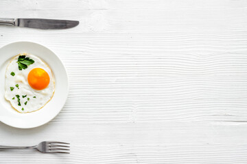 Fried eggs on plate - white wooden dinner table from above copy space