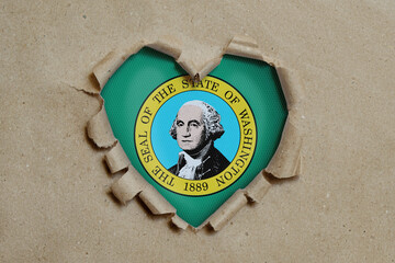 Heart shaped hole torn through paper, showing Washington flag