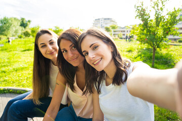 Group of three young friends smiling while taking a selfie - social media technology addicted