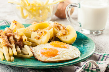 Fried eggs with boiled potatoes and yellow string beans
