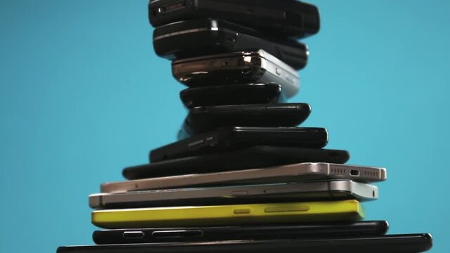 outdated and modern models of smartphones and mobile phones. dirty, broken and old smartphones on a blue background. Rotation