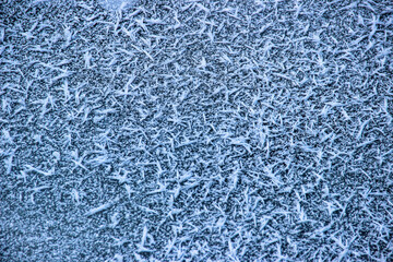 blue hoarfrost and snowflakes iced on asphalt