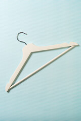 Wooden hanger on light blue background