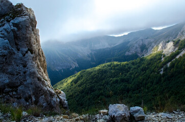 Nuvole sopra i monti e parete rocciosa