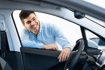 Happy Man Choosing New Auto In Dealership Store