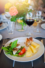 Plate with food on the table with flowers.