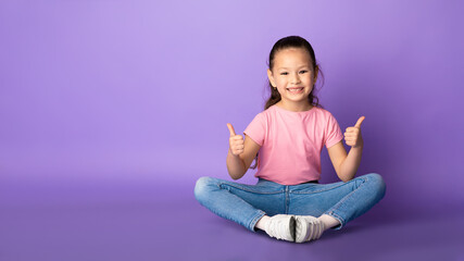 Asian girl showing thumb up and smiling