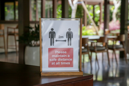 Social distancing sign at the entrance of restaurant as a reminder that everyone needs to comply with new requirements by maintaining a 2 meters distance to protect themselves and others from the Coro