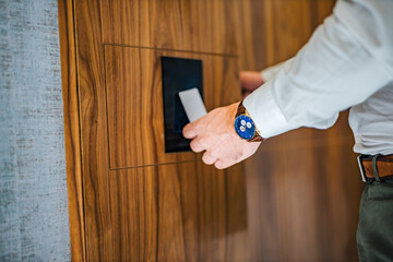 Close-up image of a businessman unlocking hotel room with a key card.