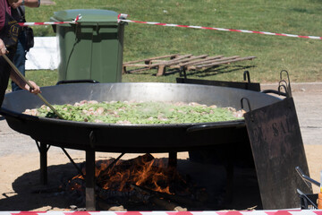 giant paella in the process of adding the vegetables