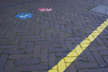 Pedestrian walking direction in a shopping street in the Netherlands marked with red and blue arrows and a yellow line to keep distance to avoid corona Covid-19 contamination