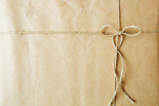 Overhead view of a single holiday package wrapped with eco friendly craft paper and tied with twine