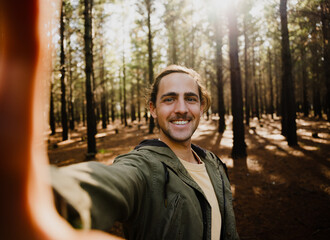 Self portrait of young happy male in the woods, selfie - Powered by Adobe