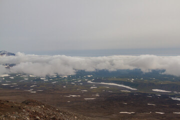 Daytime view of the stony wasteland in daytime; View of the volcano on the horizon in clear weather