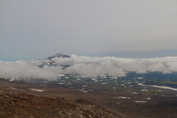 Daytime view of the stony wasteland in daytime; View of the volcano on the horizon in clear weather