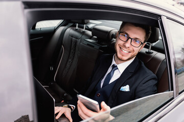 Businessman sitting in luxury car looking out of window