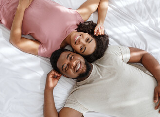 Top view of african loving couple lying in bed together