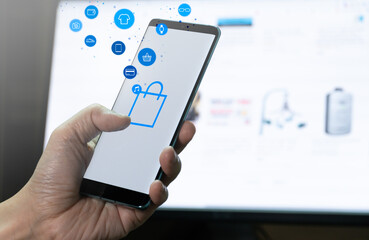 mobile phone in hand with shopping button and product icon flow. Concept for mobile application technology and online e-commerce.