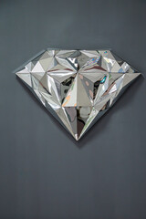 decorative diamond is hanging on the grey wall, vertical image