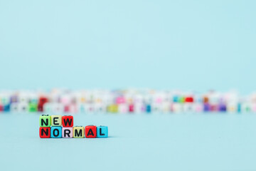 NEW NORMAL word with letter beads on yellow background for a new way of living concept