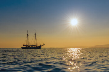 beautiful sailing yacht on the horizon at sunset, beautiful natural landscape
