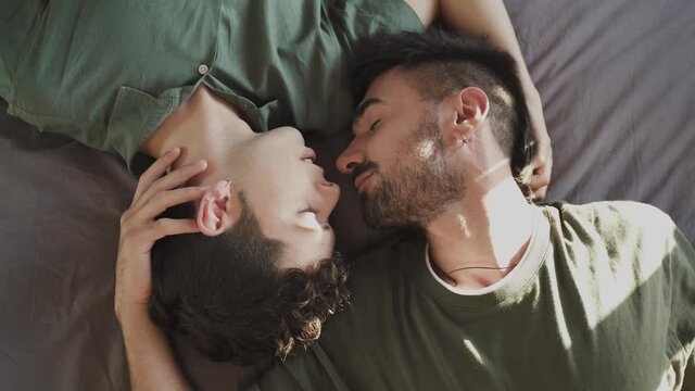 Gay boy couple lying in bed kissing. LGBT