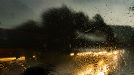 Nachts unterwegs mit dem Auto, wenn Starkregen gegen die Windschutzscheibe prallt. Schlechte Sicht,...