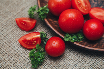 Red ripe tomatoes on a wooden plate close-up