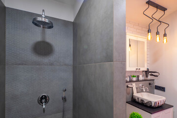 Modern loft interior of luxury bathroom. White sink. Brick wall. Grey tile in shower.