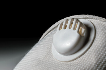 Close up shot of the respirator of a N95 mask to wear for COVID 19. Dark background
