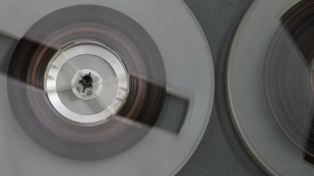 Vintage reel to reel tape recorder playing music. Spinning reels on old tape recorder. Close up. Play.